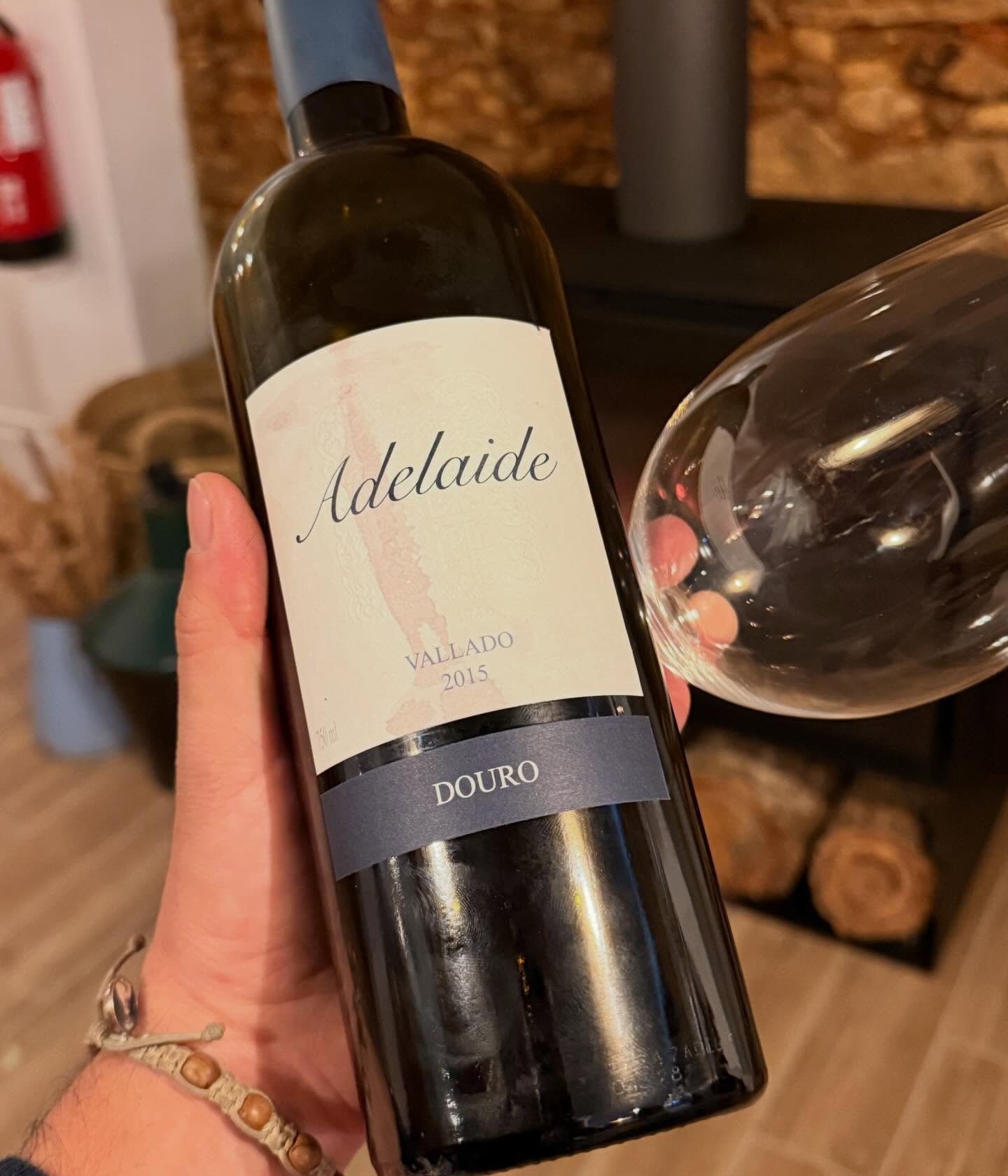 Mão a segurar uma garrafa de Adelaide 2015, do Douro, junto a um copo